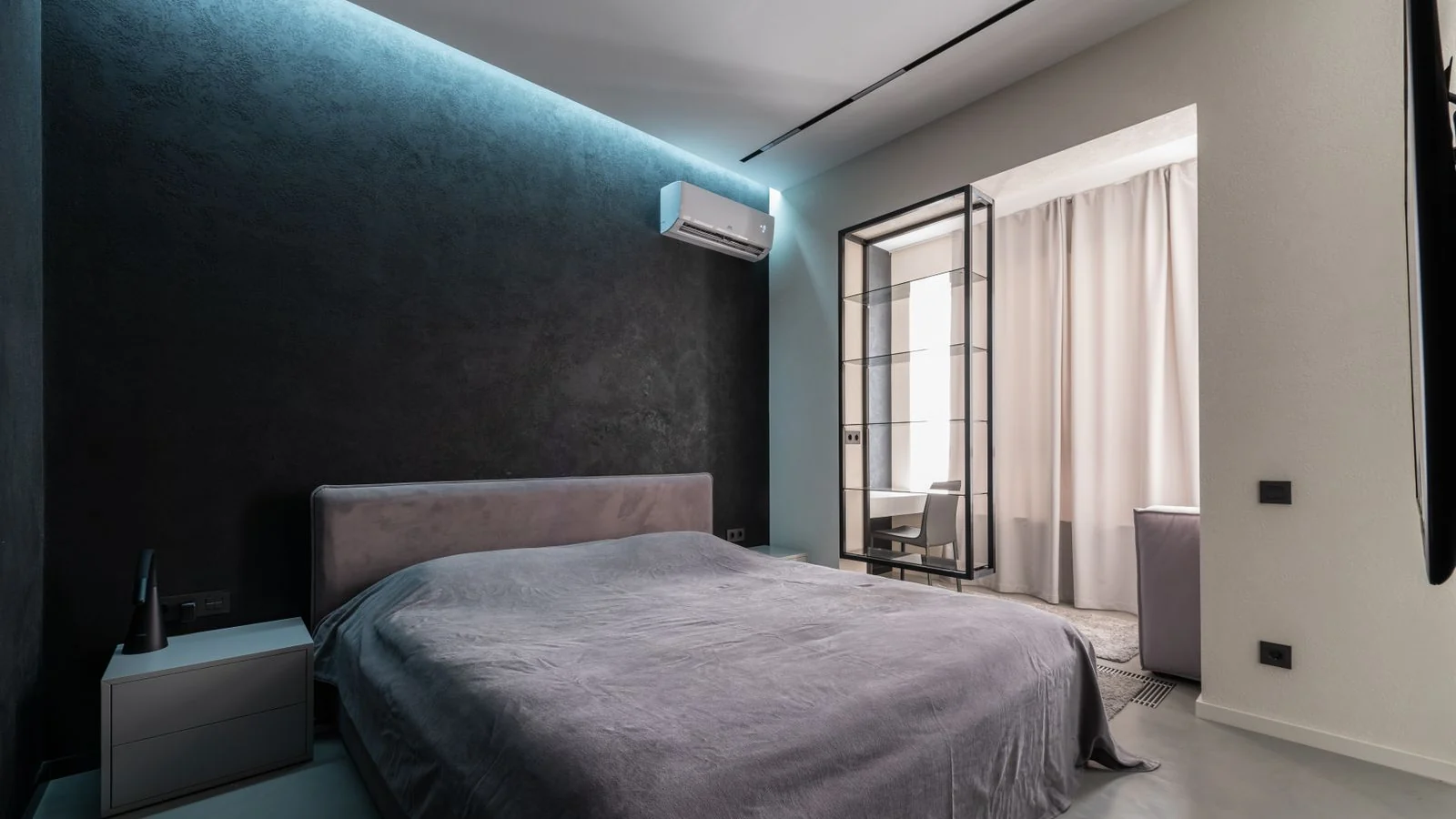 Unit aircond dinding putih di dalam ruang tamu rumah, jenis unit yang paling kerap dikira dalam harga servis aircond rumah.